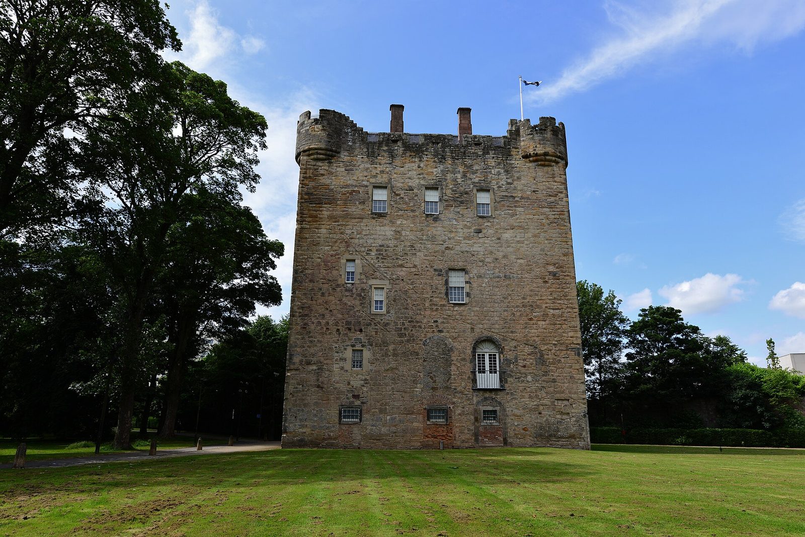 Alloa Tower, a tall four-storey medieval keep of pale stone standing above lawns.